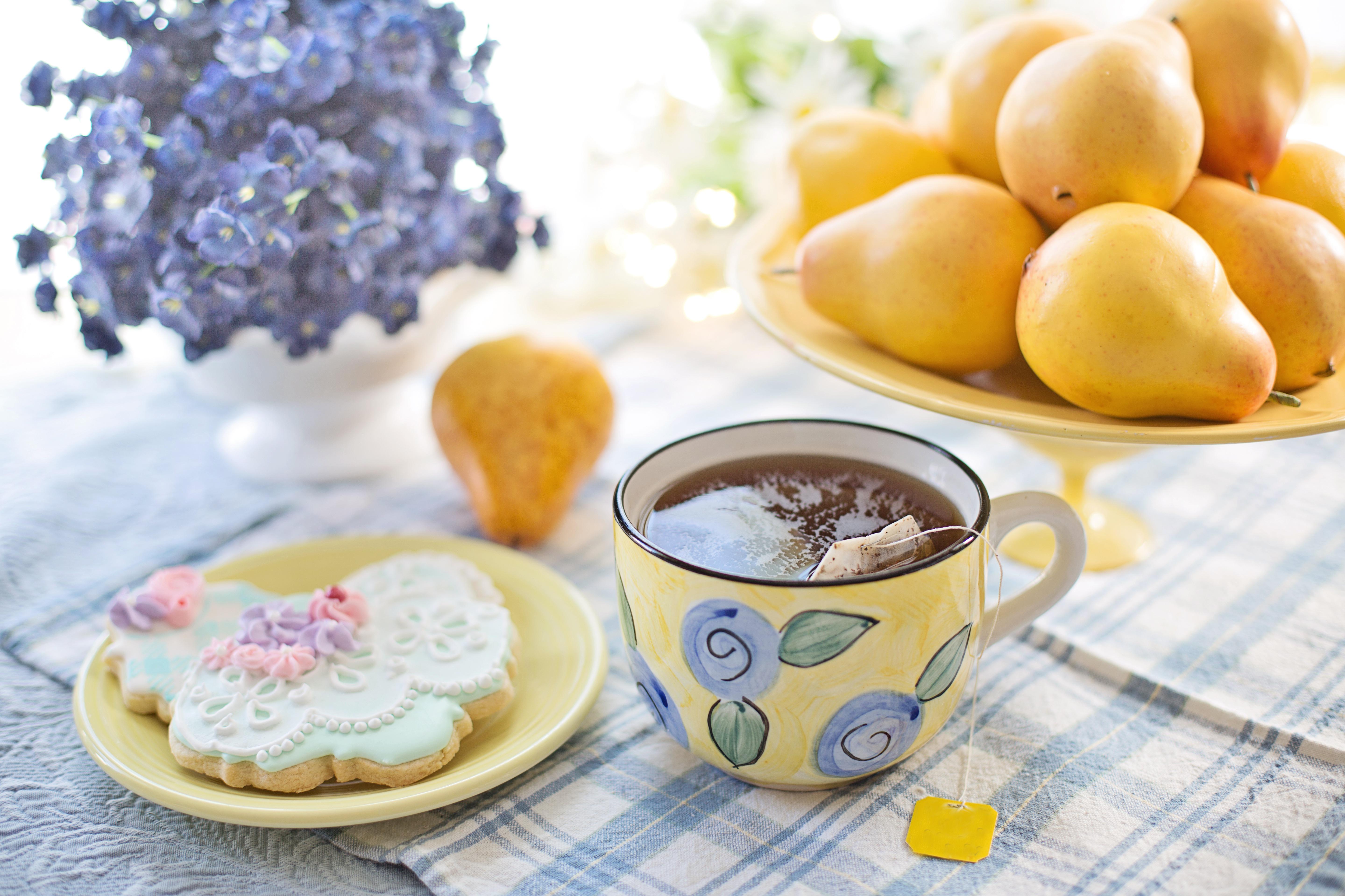 Teacup biscuit and flowers on table